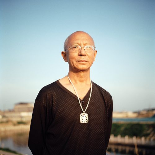 阳光下挂喜字牌的老年人，唐山市路北区，2023年5月